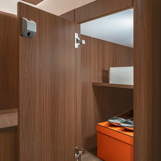 geöffneter Kleiderschrank mit Regalfachböden, gefüllt mit oranger Schachtel und silberfarbenen Ballerinas im HYMER B-ML T